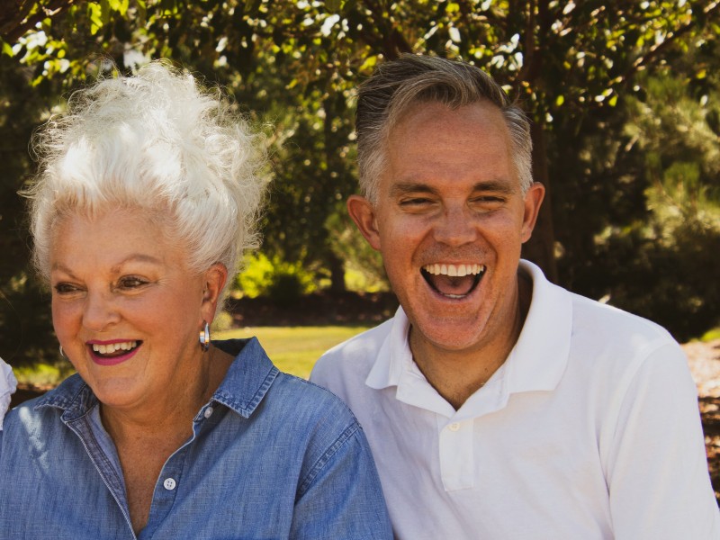patient smiling outdoors with healthy teeth and restored smile after implants