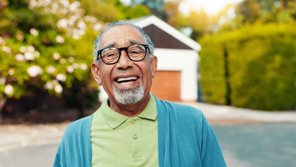 man smiling confidently with healthy teeth after dental treatment for Dentures and Partials