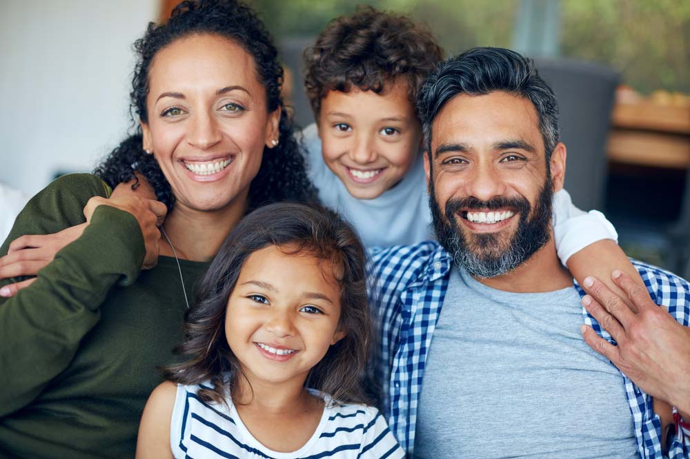 Family smiling confidently with bright healthy smiles and teeth after Emergency Dentistry