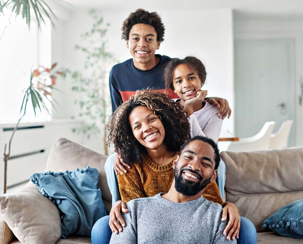 Happy family at home showing healthy smiles after dental visits for General Dentistry in Southfield, MI