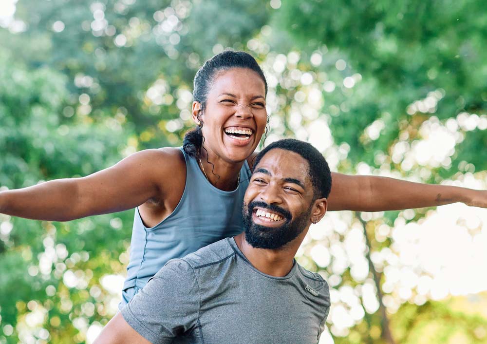 Happy couple smiling outdoors with healthy bright smiles after IV Sedation treatment