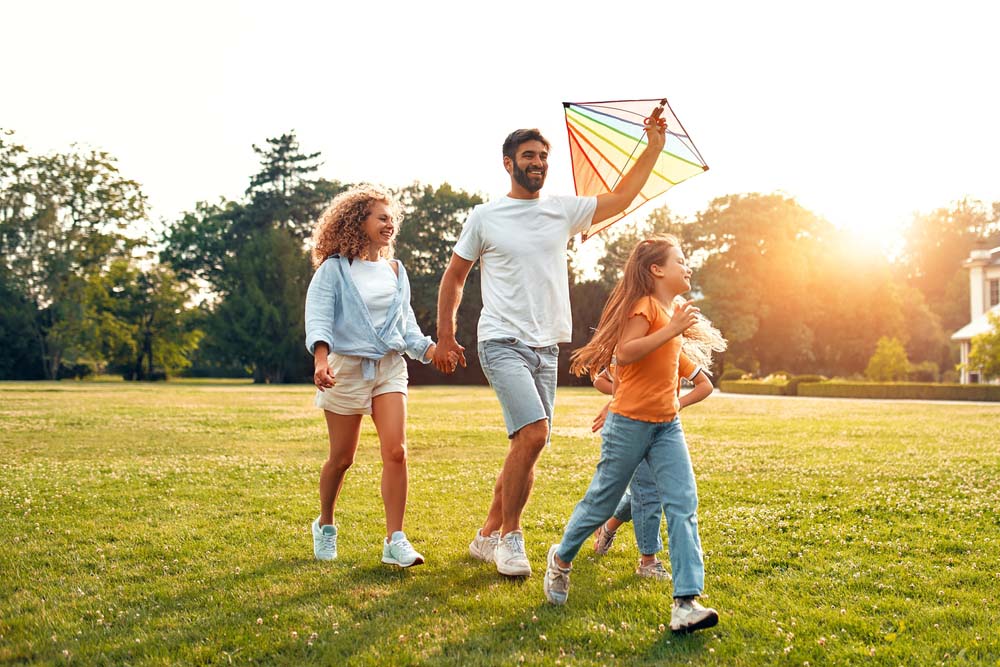 Family enjoying outdoor activities with healthy confident smiles after IV Sedation in Southfield, MI