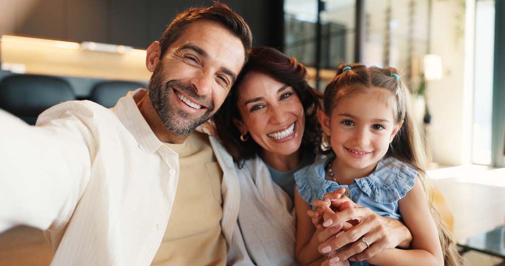 Happy family smiling with healthy teeth and confident smiles after TMJ Therapy in Livonia MI