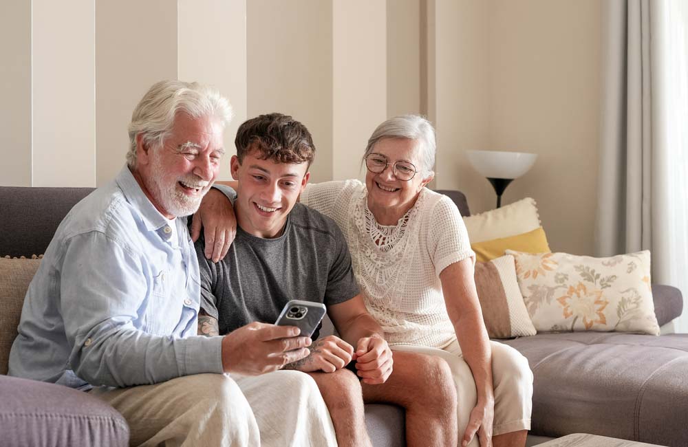 Grandparents and grandson smiling together with healthy family smiles after Dental Implants