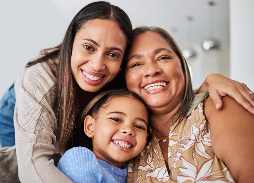 Smiling family showing healthy teeth after family dental visits and TMJ Treatment