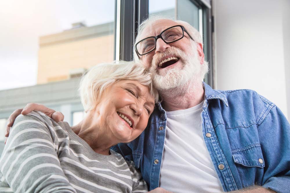 couple laughing together with healthy smiles after TrueDent Dentures