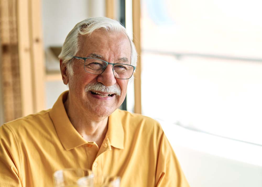 man smiling comfortably after restorative dental care TruDent Dentures