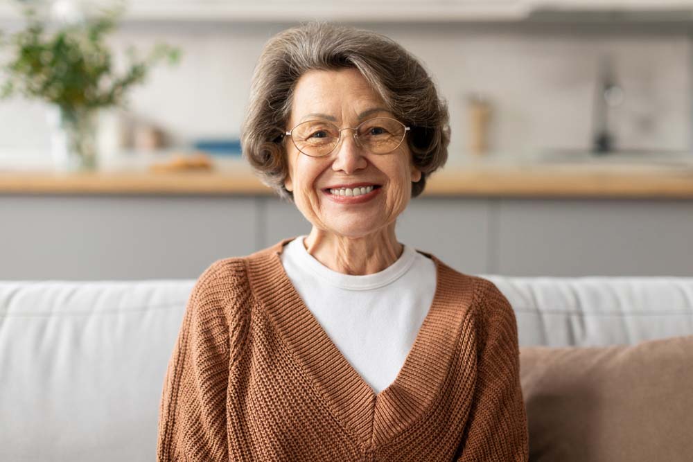 Senior woman smiling after restorative and TrueDent Dentures