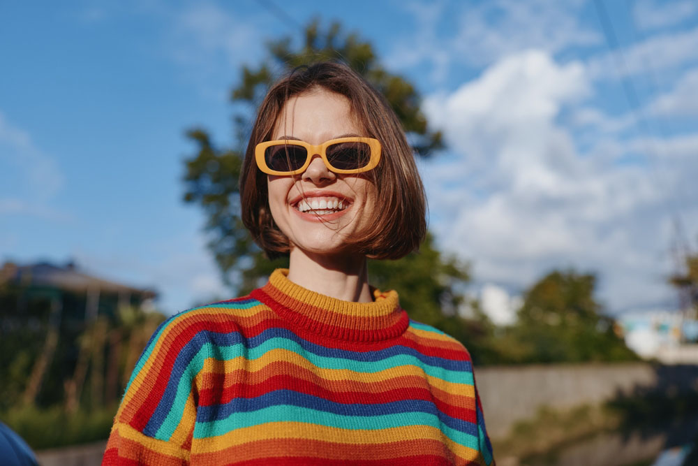Woman outdoors smiling with bright healthy teeth and confident smile after Emergency Dentistry