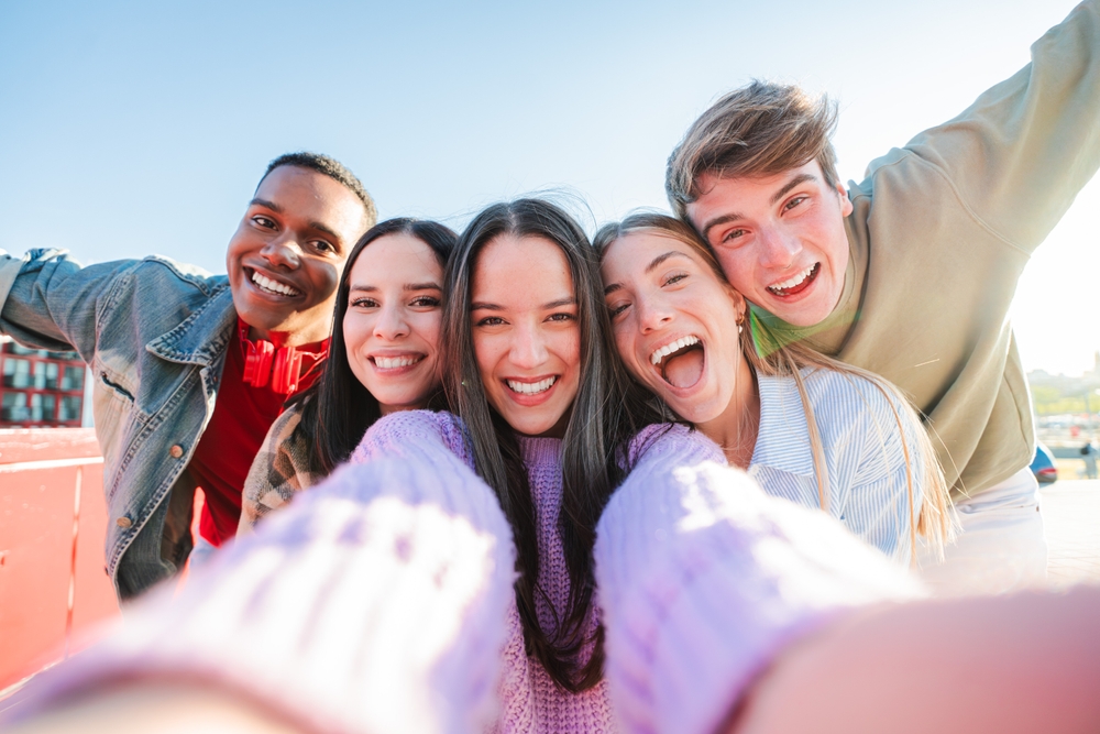 Group of friends smiling confidently with healthy white teeth